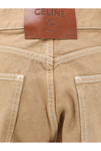 Tan celine paris denim jeans with white stitching and brown leather brand label shown from the back side