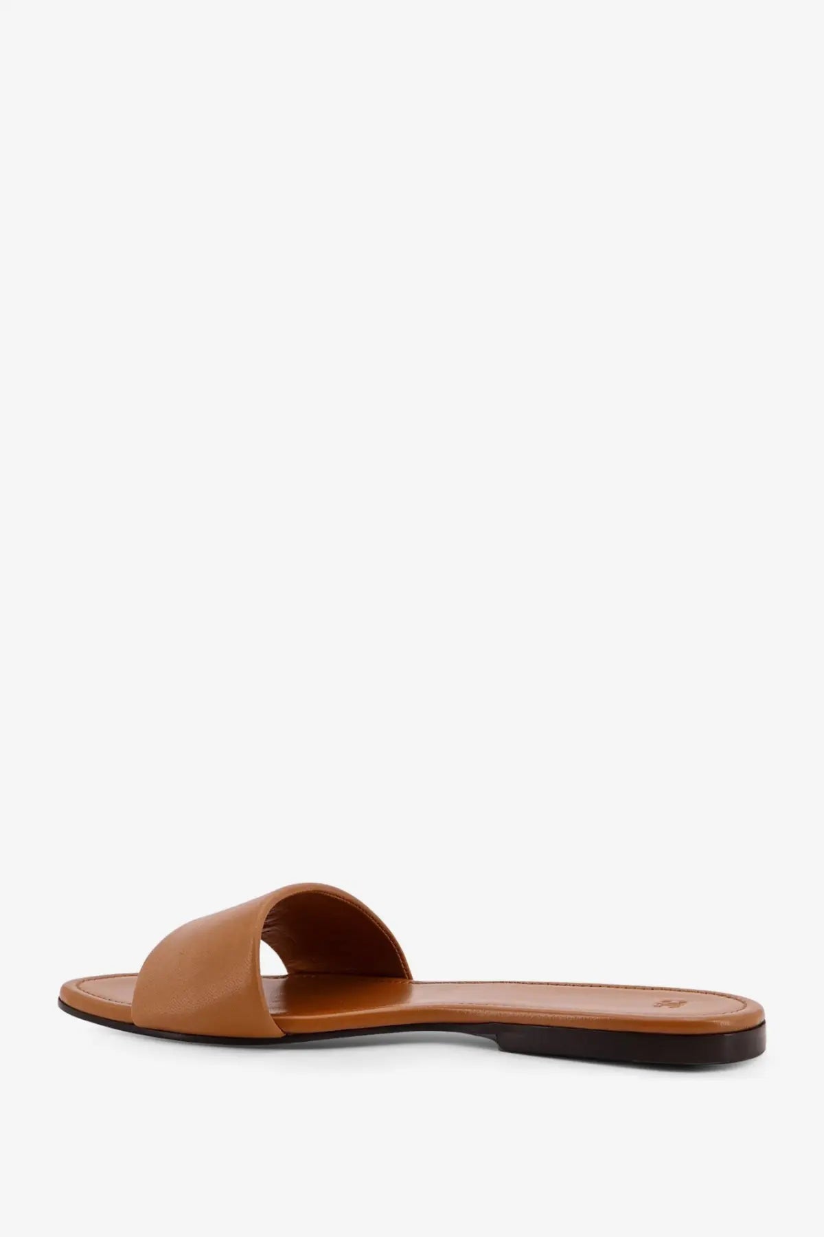 Tan leather slide sandal with minimalist design and black rubber sole from celine women’s coast mule collection sahara