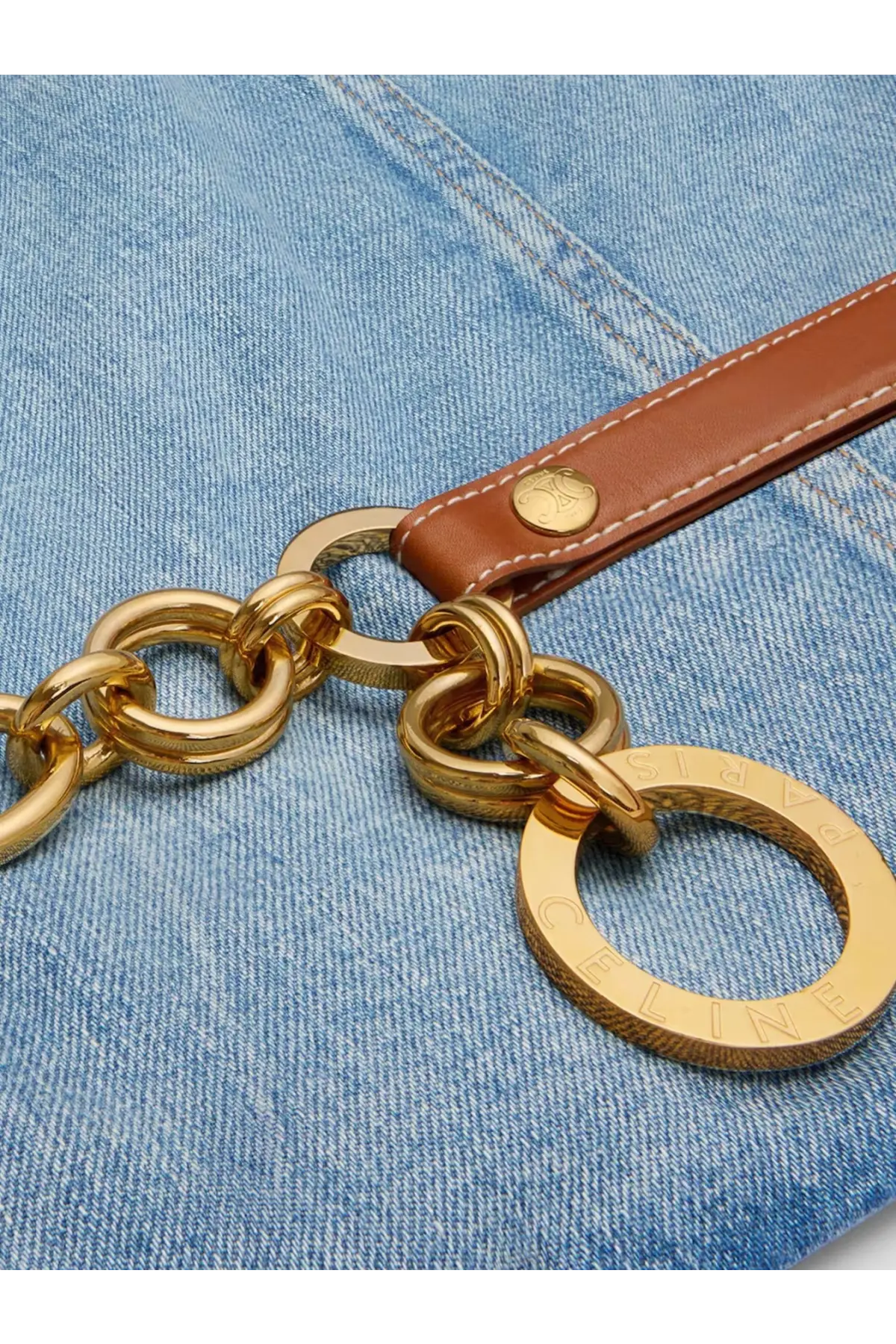 Gold-tone chain strap with brown leather tab and circular celine logo tag on celine women’s blue denim jacket