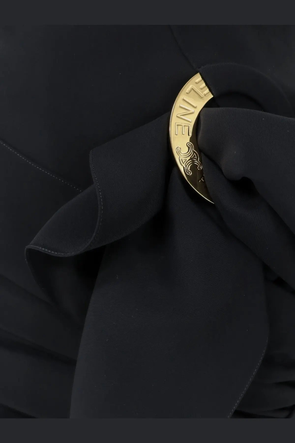 Gold-toned circular brooch with engraved zine and ornate scrollwork fastened to celine women’s draped mini skirt black fabric