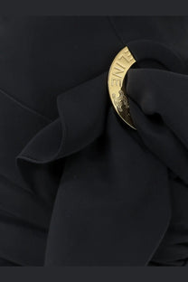 Gold-toned circular brooch with engraved zine and ornate scrollwork fastened to celine women’s draped mini skirt black fabric