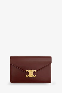 Celine women’s margo leather crossbody bag in brown featuring a sleek burgundy leather clutch with gold c-shaped clasp