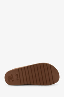 Back view of celine women’s pitea suede sandals with brown rubber sole textured ribbed pattern and celine logo embossed