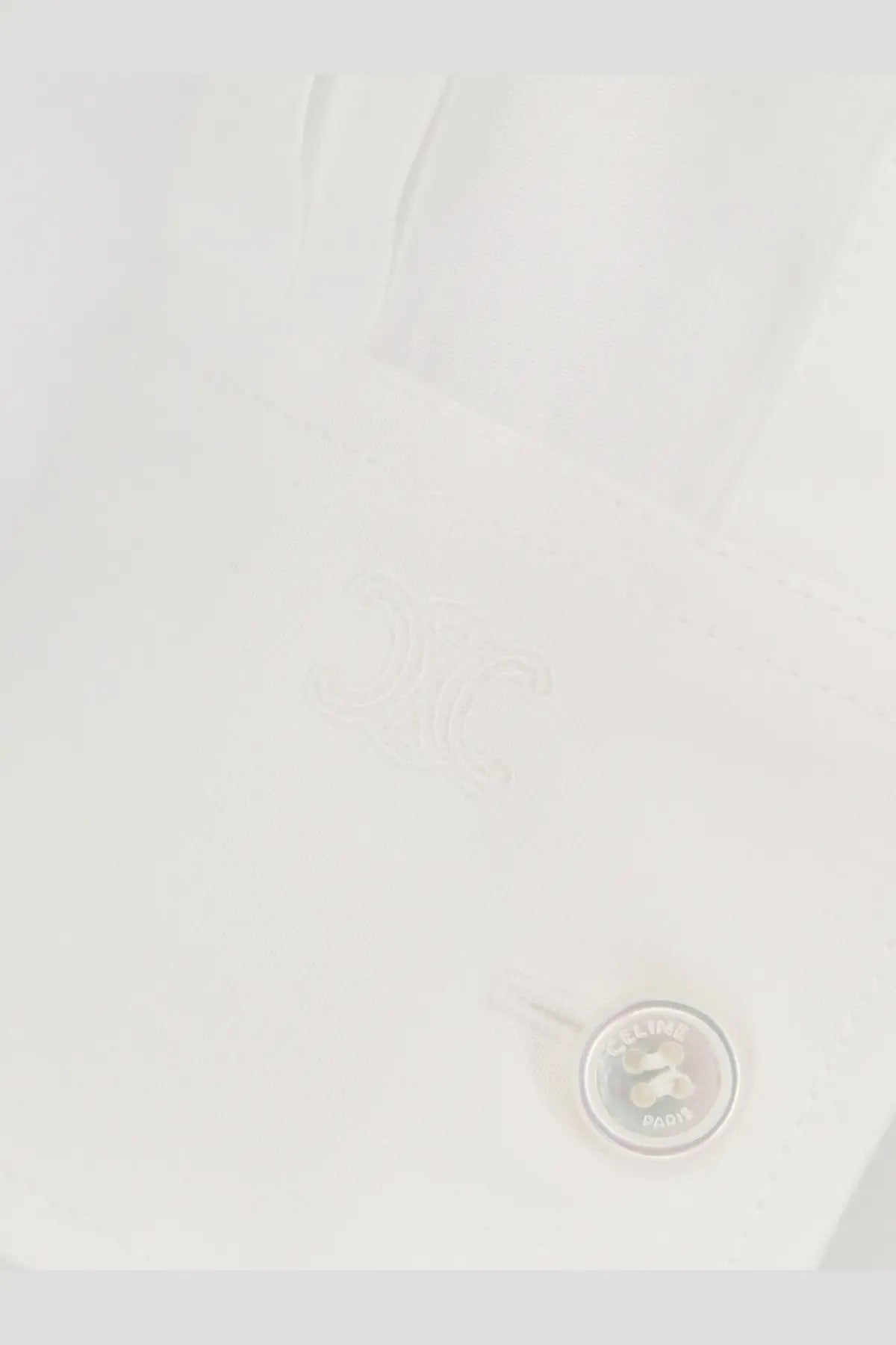 White button engraved with celine paris on a relaxed white cotton shirt for women