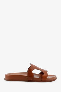 Beige celine women’s triomphe leather slide sandal with a minimalist sculpted strap design