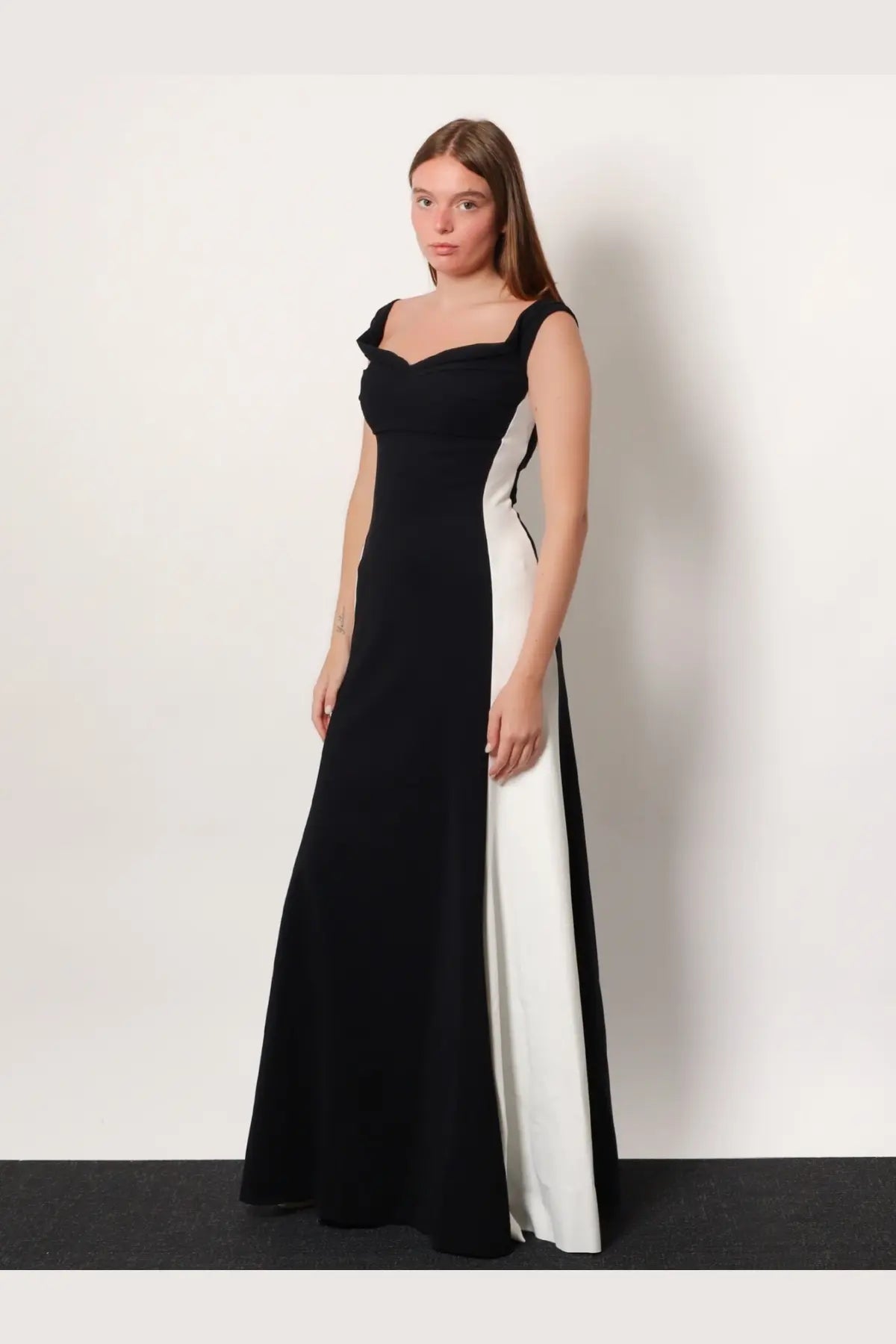 A sleek black and white two-tone satin evening gown with fitted bodice and square neckline by Chiara Boni