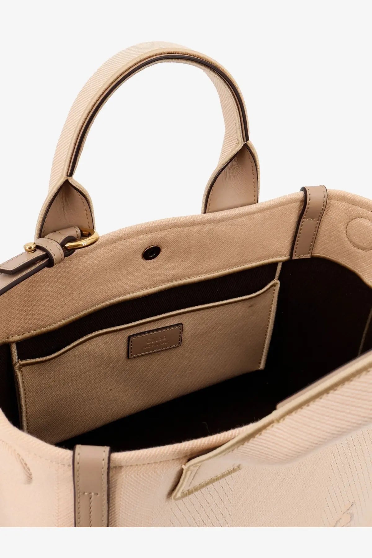Beige canvas chloé carry crossbody bag with structured handles and minimalist interior pocket for women