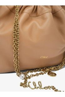 Beige leather drawstring Chloé crossbody bag with gold-tone chain strap featuring pearl and coin charms