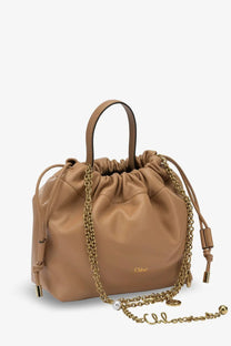 Tan leather drawstring crossbody bag with gold-tone chain strap and pearl accent from Chloé women’s beige collection