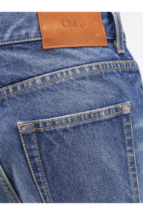 Blue denim jeans with a tan leather chloé paris patch on the back for women