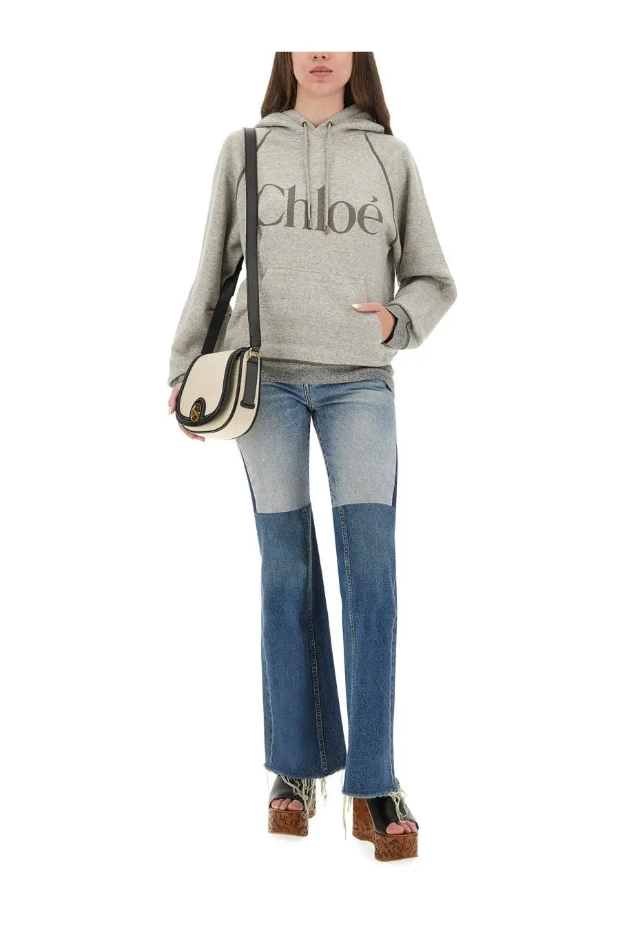 Cream and black leather crossbody bag with circular gold-tone clasp paired with chloé women’s oversized grey hoodie