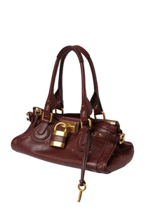 A burgundy leather chloé women’s paddington bag with gold-tone hardware and a prominent padlock closure