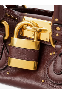 A burgundy leather chloé women’s shoulder bag with gold-tone padlock closure and embossed brand name on strap