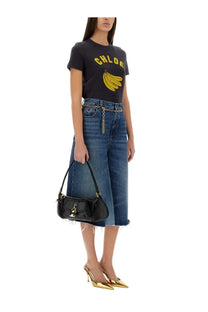 Black leather handbag with gold-tone lock and chain strap shown with chloé women’s patchwork denim bermuda shorts blue