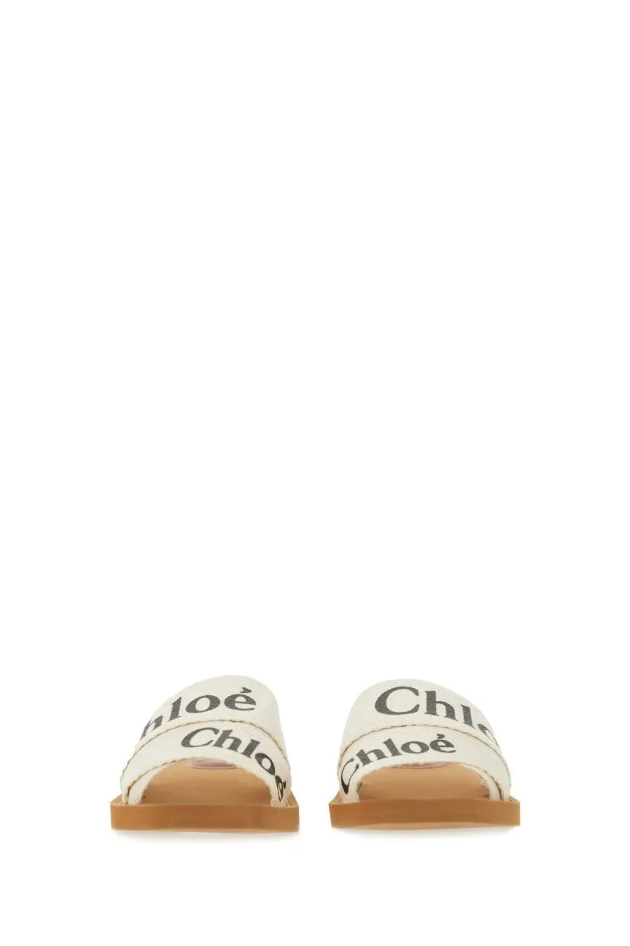 Cream-colored canvas slide sandals with black chloé branding on straps from chloé women’s sandal woody white collection