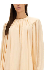 Chloé women’s silk shirred mini dress pink with a soft cream-colored flowing blouse featuring gathered neckline and puffy sleeves