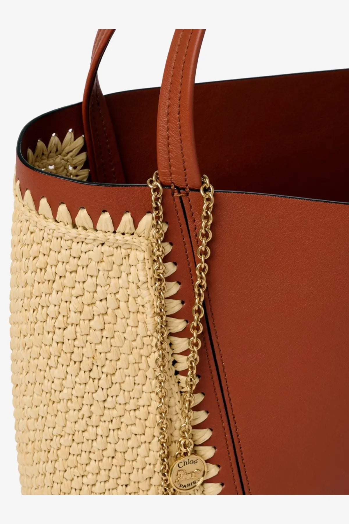 A tan woven straw and brown leather Chloé tote bag with gold chain strap and Chloé Paris logo charm
