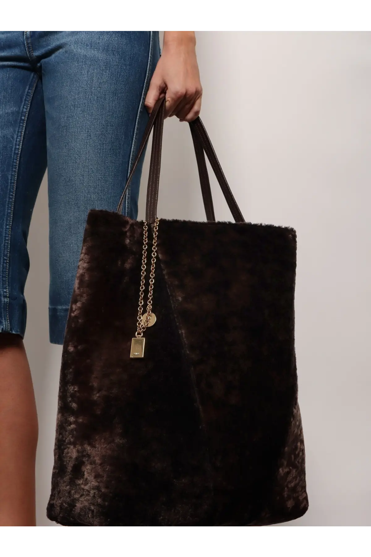 A plush dark brown velvet tote bag with long handles and gold chain charm from chloé women’s spin shearling shoulder bag brown