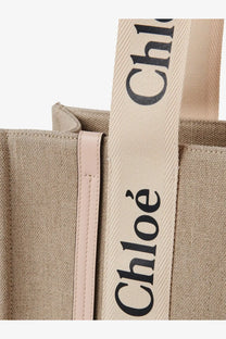 Beige canvas chloé tote bag with black lettering strap and pink leather trim featured in chloé woody linen shoulder bag blue