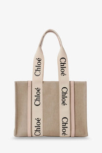 Beige canvas chloé tote bag with cream handles and black lettering in the style of woody linen shoulder bag blue
