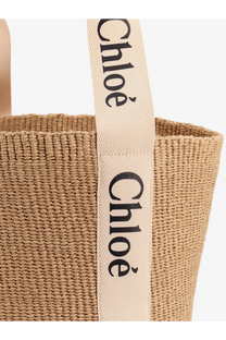 Beige woven straw tote bag with cream fabric handles and black chloé branding for women by chloé woody raffia shoulder bag white