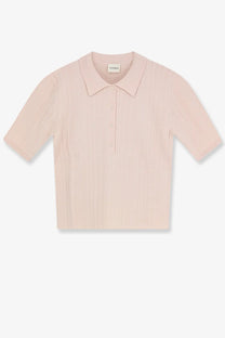 A soft blush pink ribbed knit polo shirt with a classic collar and button placket for women
