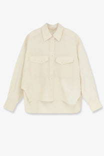 Cream-colored long-sleeved cropped silk shirt for women with button-up front, two chest pockets, and asymmetrical hem