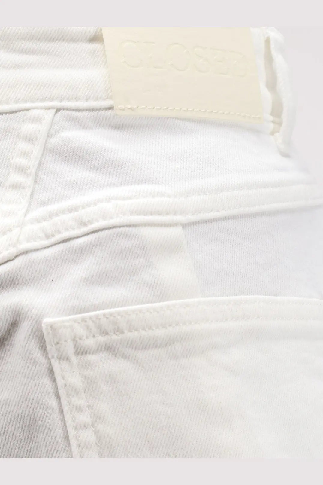 White closed women’s jocy stretch cotton denim shorts showing back with cream leather brand tag on waistband