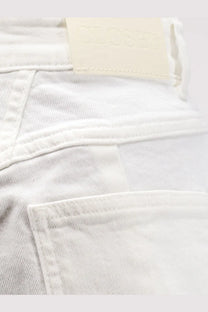 White closed women’s jocy stretch cotton denim shorts showing back with cream leather brand tag on waistband