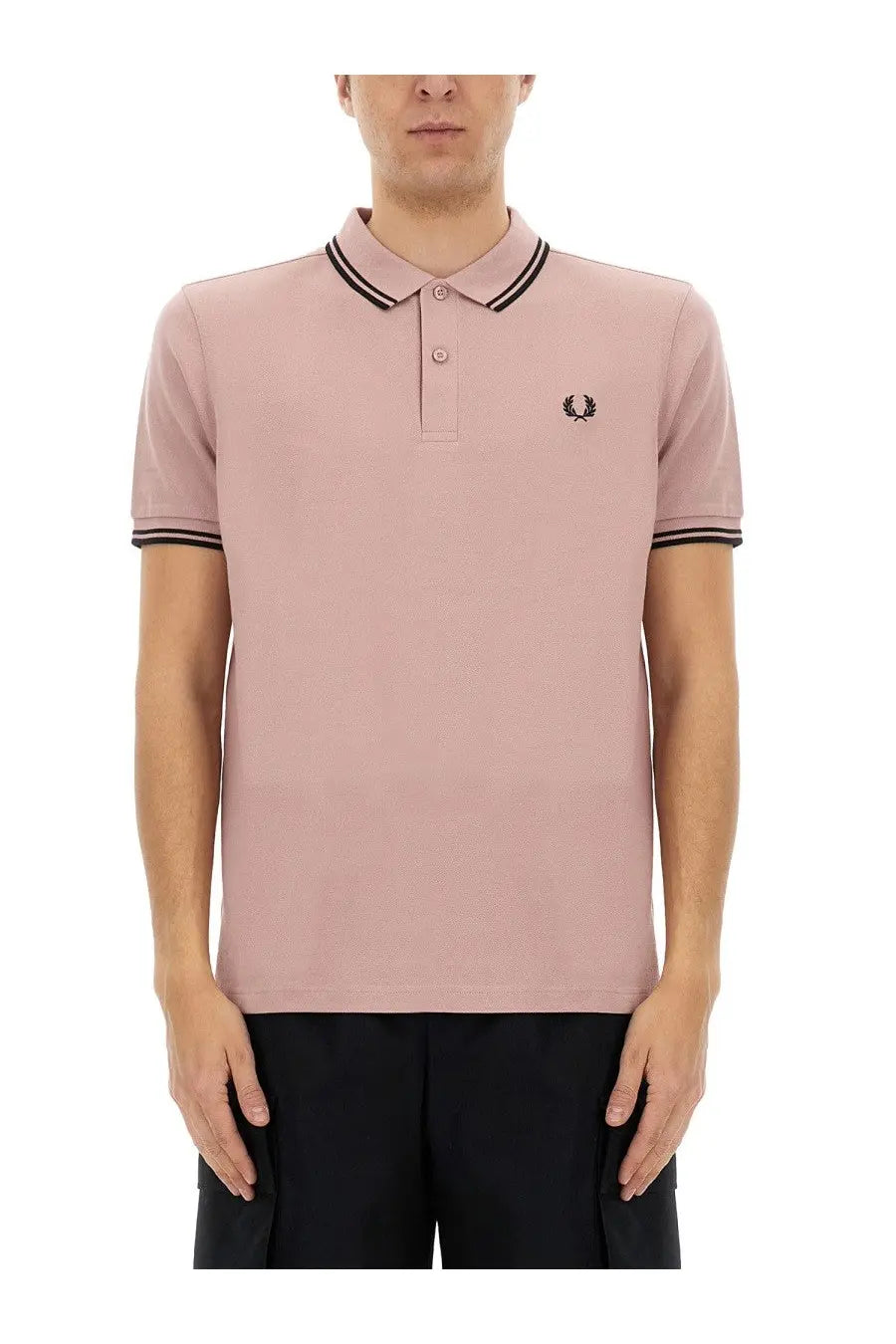A soft pink fred perry polo shirt with black trim and an embroidered logo on the chest from comme des garcons shirt