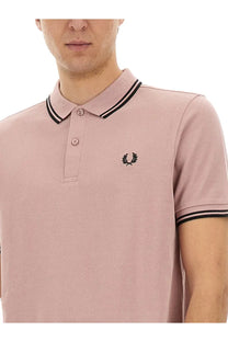 A soft pink Comme Des Garcons shirt men’s polo Freedom Blue with black trim and embroidered laurel wreath logo