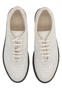 Common Projects men’s bball slim sneaker in white leather with black rubber soles and perforated toe panels