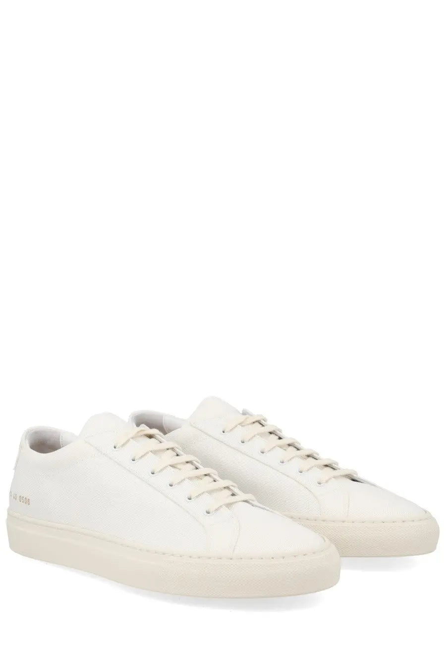 Pair of common projects men’s minimalist white leather sneakers shown from the back with clean stitching and logo
