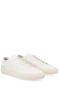 Pair of common projects men’s minimalist white leather sneakers shown from the back with clean stitching and logo