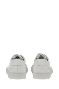 Common projects women’s low original achilles sneaker white leather low-top with minimalist design and subtle heel branding from back view