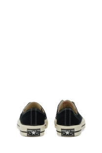 Black canvas converse unisex chuck sneaker low-top showing back side with white rubber sole and classic star logo on heel