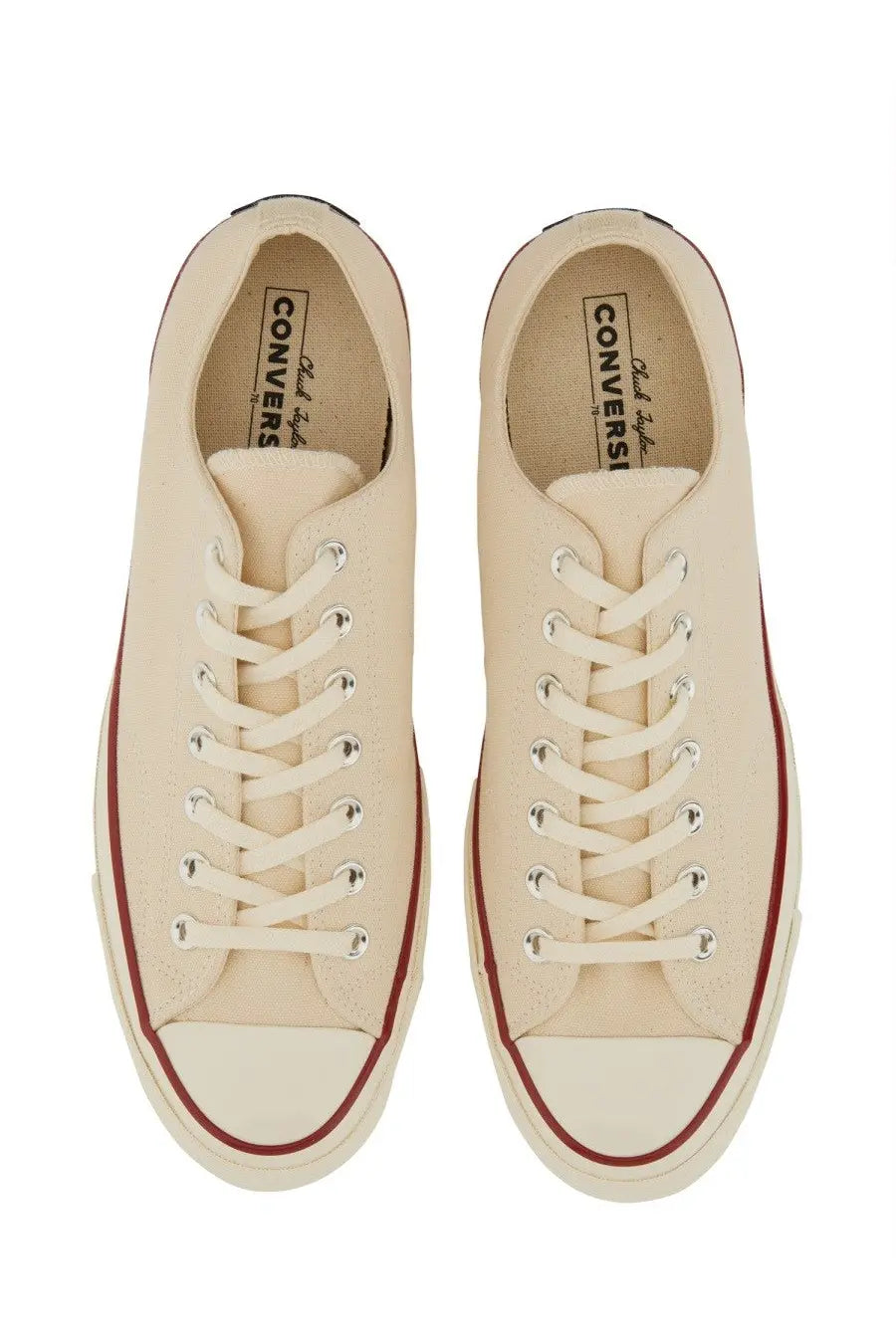 Cream-colored canvas converse unisex chuck sneaker with red rubber sole trim and white toe cap