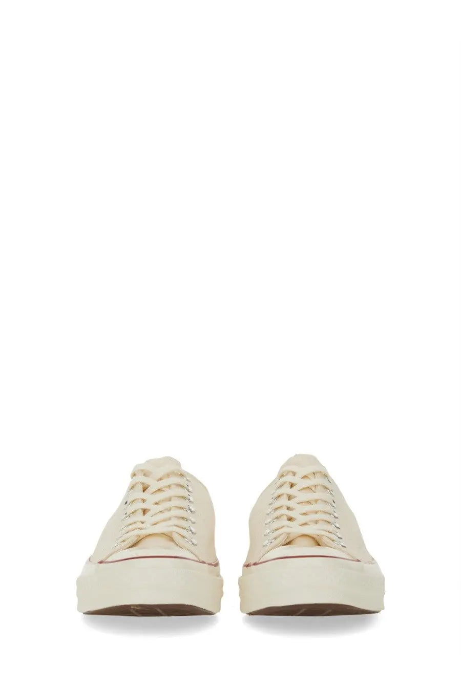 Cream-colored canvas converse unisex chuck sneaker with white rubber soles and matching laces front view