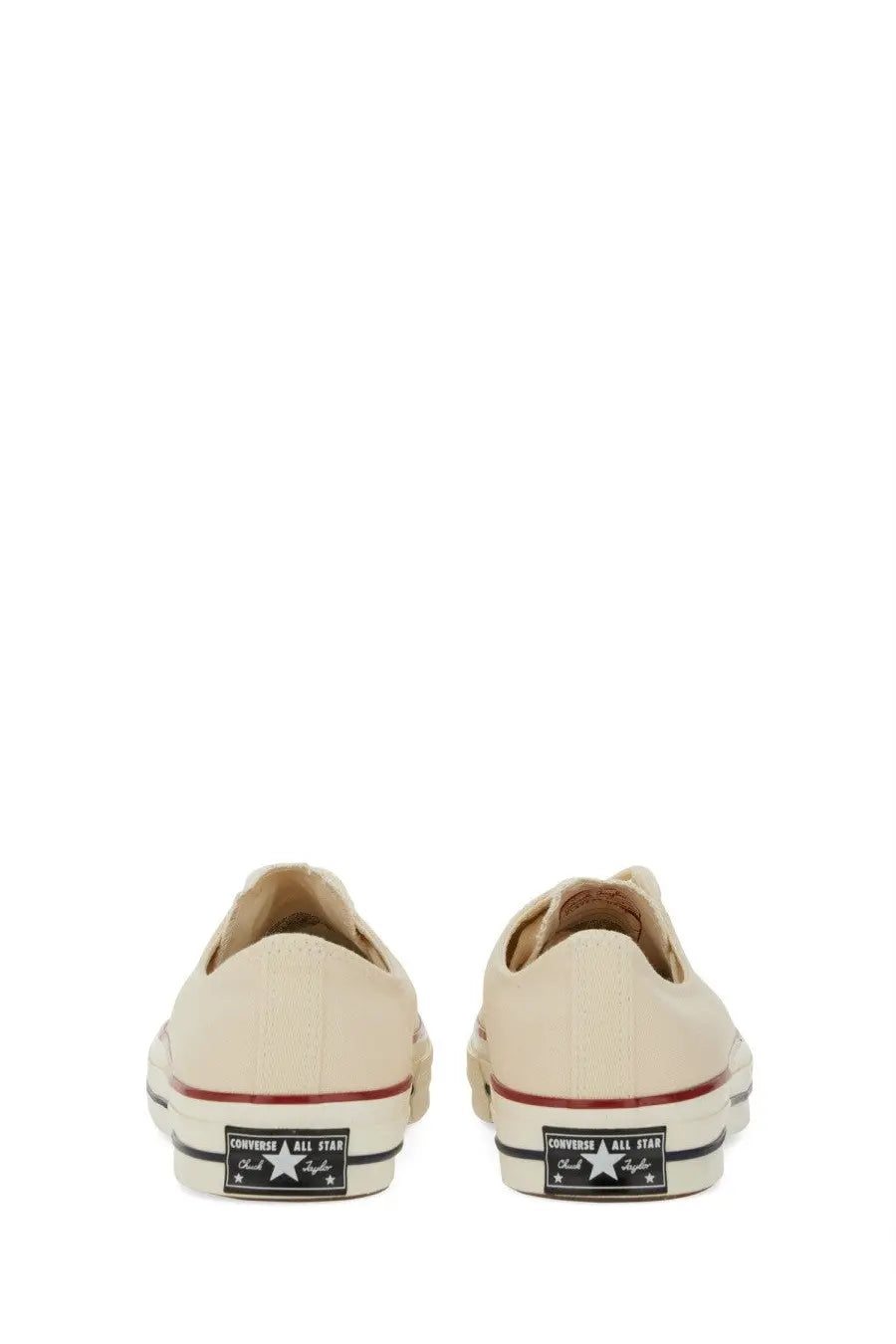 Cream-colored canvas converse unisex chuck sneaker low-top with red and black rubber soles