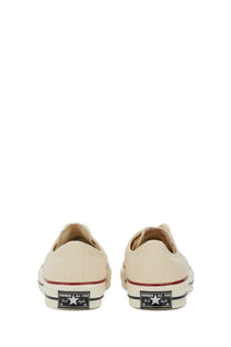Cream-colored canvas converse unisex chuck sneaker low-top with red and black rubber soles