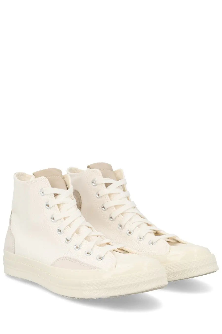 Cream-colored unisex Converse Chuck high-top sneakers with canvas upper, rubber sole, white laces, and metallic eyelets