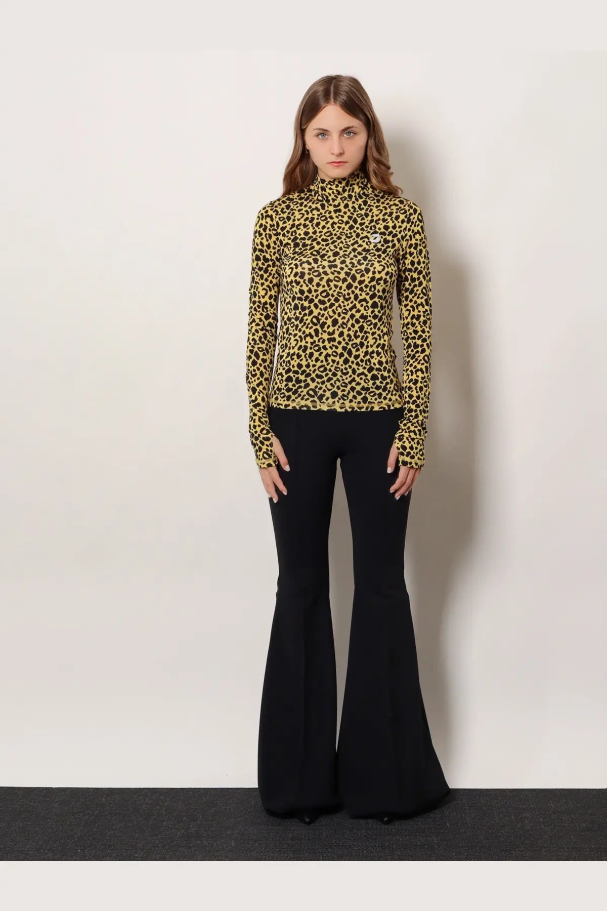 A mustard yellow leopard print knitted viscose long sleeve turtleneck top by Coperni with a small chest logo
