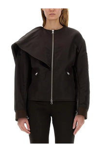 Woman wearing black asymmetrical bomber jacket with silver zippers and subtle texture by courrèges