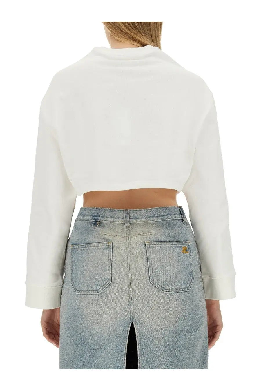 Courrèges women’s white cropped sweatshirt in long sleeve style paired with light-wash denim pants