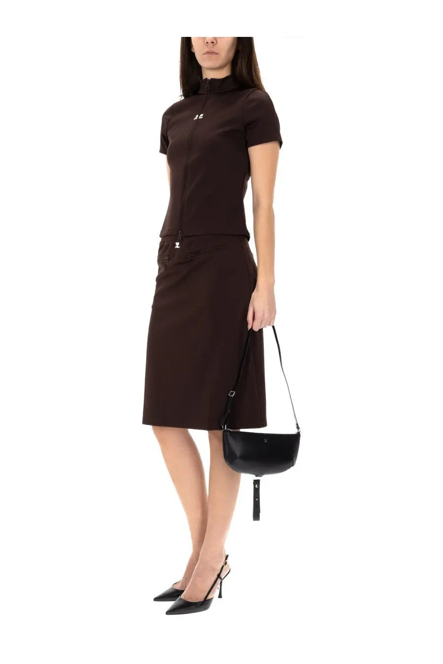 Black leather mini crossbody bag with sleek minimalist design and tassel detail shown with courrèges women’s brown midi skirt