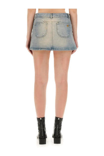 Back view of courrèges women’s light-wash denim mini skirt with two pockets and subtle distressed finish in blue