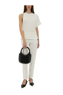 Black leather handbag with circular handle and minimalist design paired with courrèges white one shoulder shirt