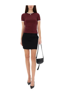 Black leather mini crossbody bag with tassel detail and silver logo hardware featured with courrèges signature red shirt