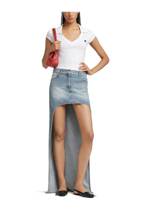 Light-wash denim skirt with a high slit and flowing asymmetrical hemline paired with courrèges women’s white sports polo