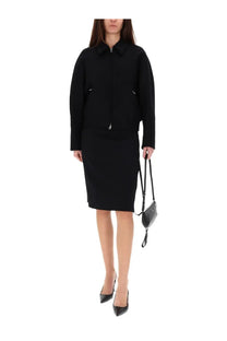 Black leather mini bag with sleek curved design and short strap paired with courrèges women’s black wool bomber jacket